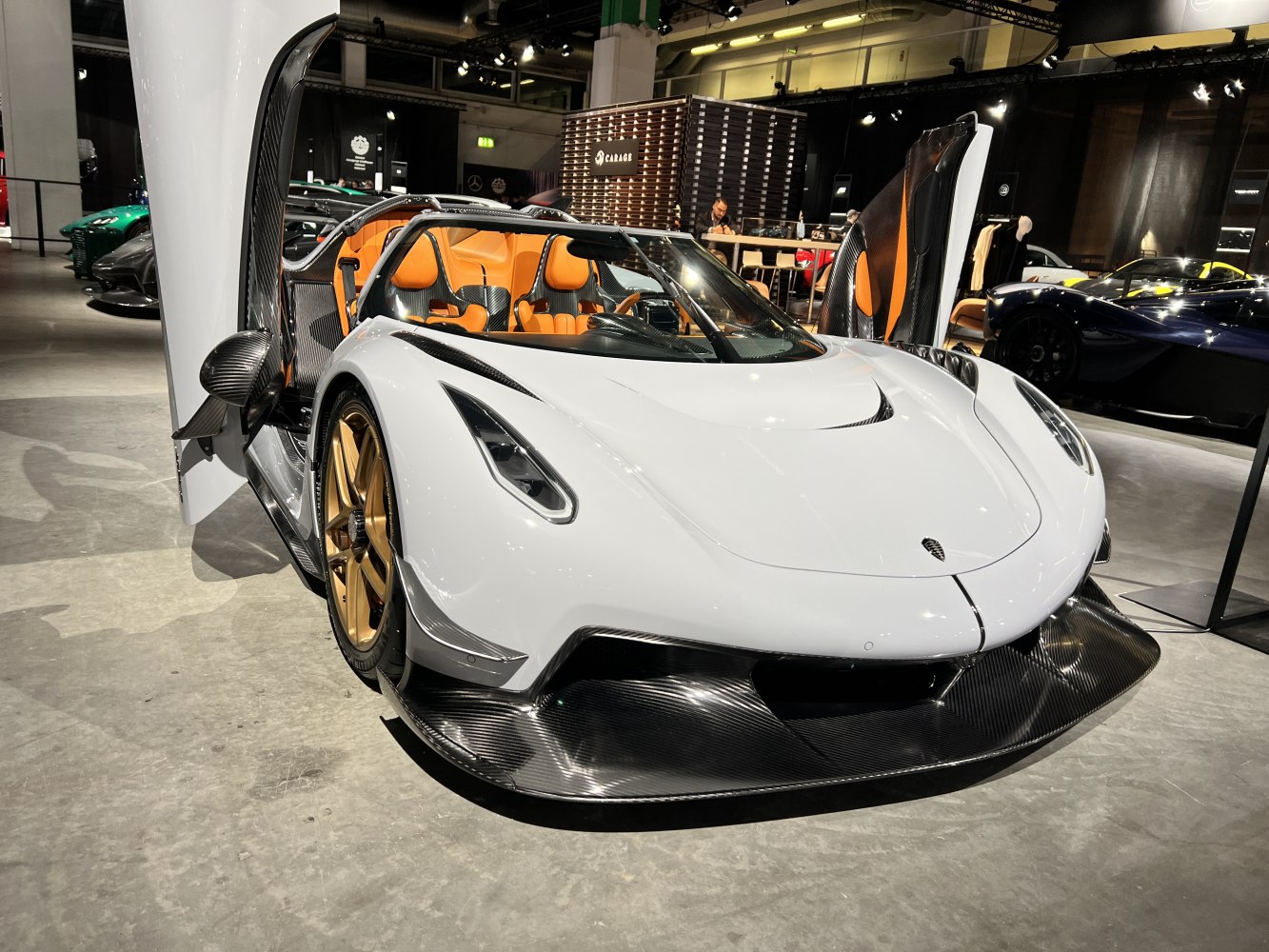 White hypercar with butterfly doors and carbon fiber front splitter