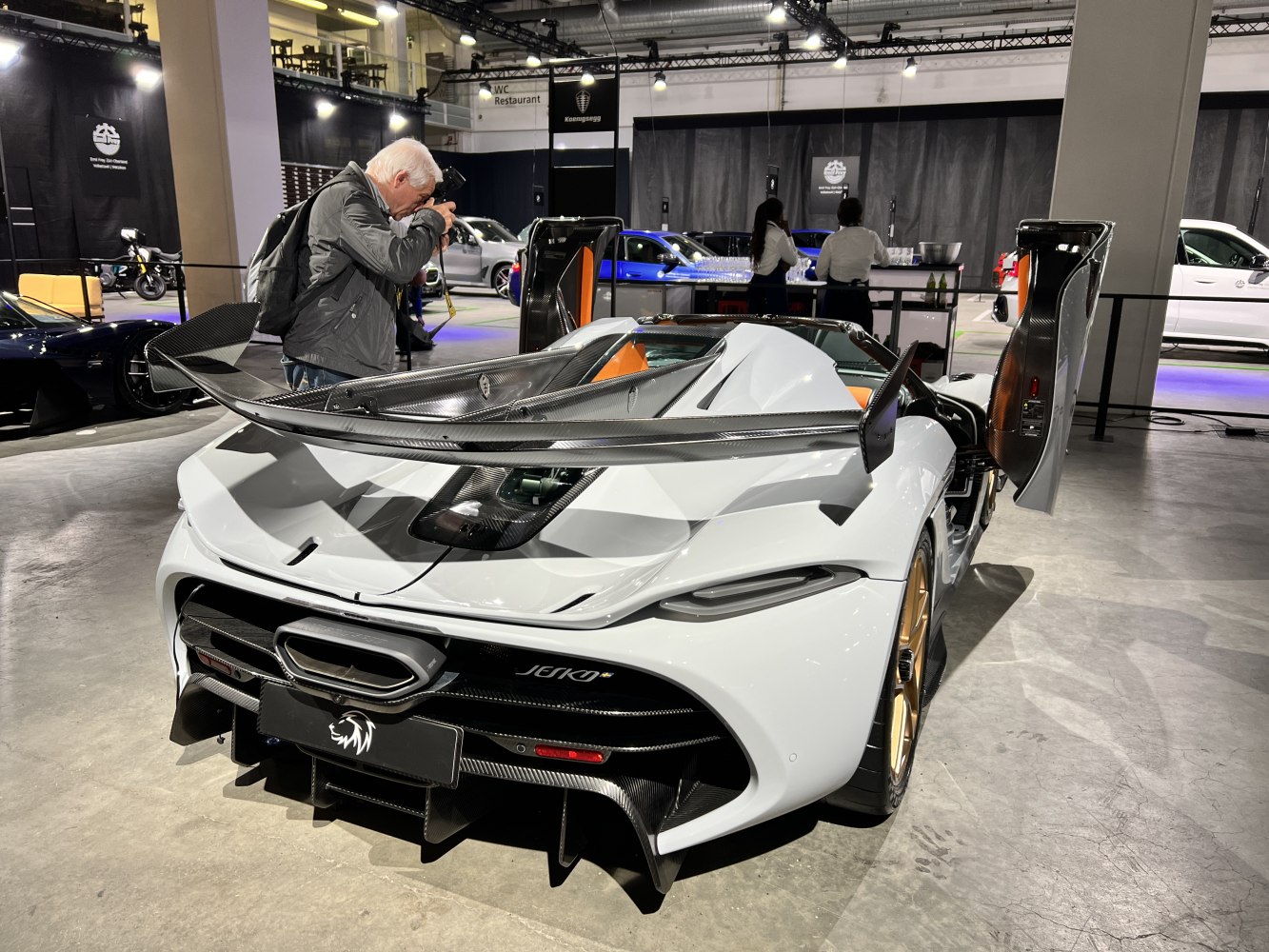 Rear view with carbon fiber wing and upward-opening doors.