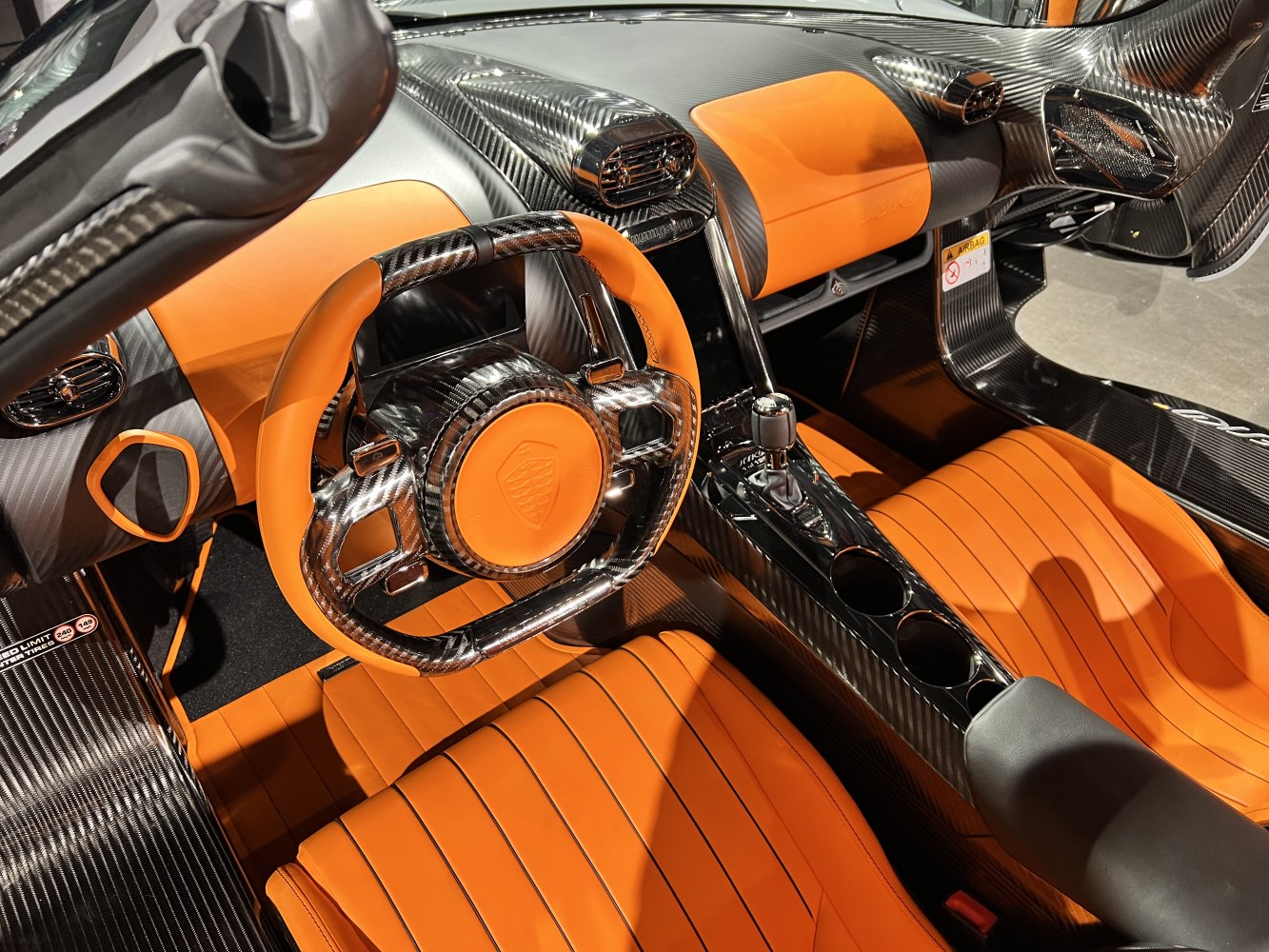 Carbon fiber steering wheel and orange leather seats.