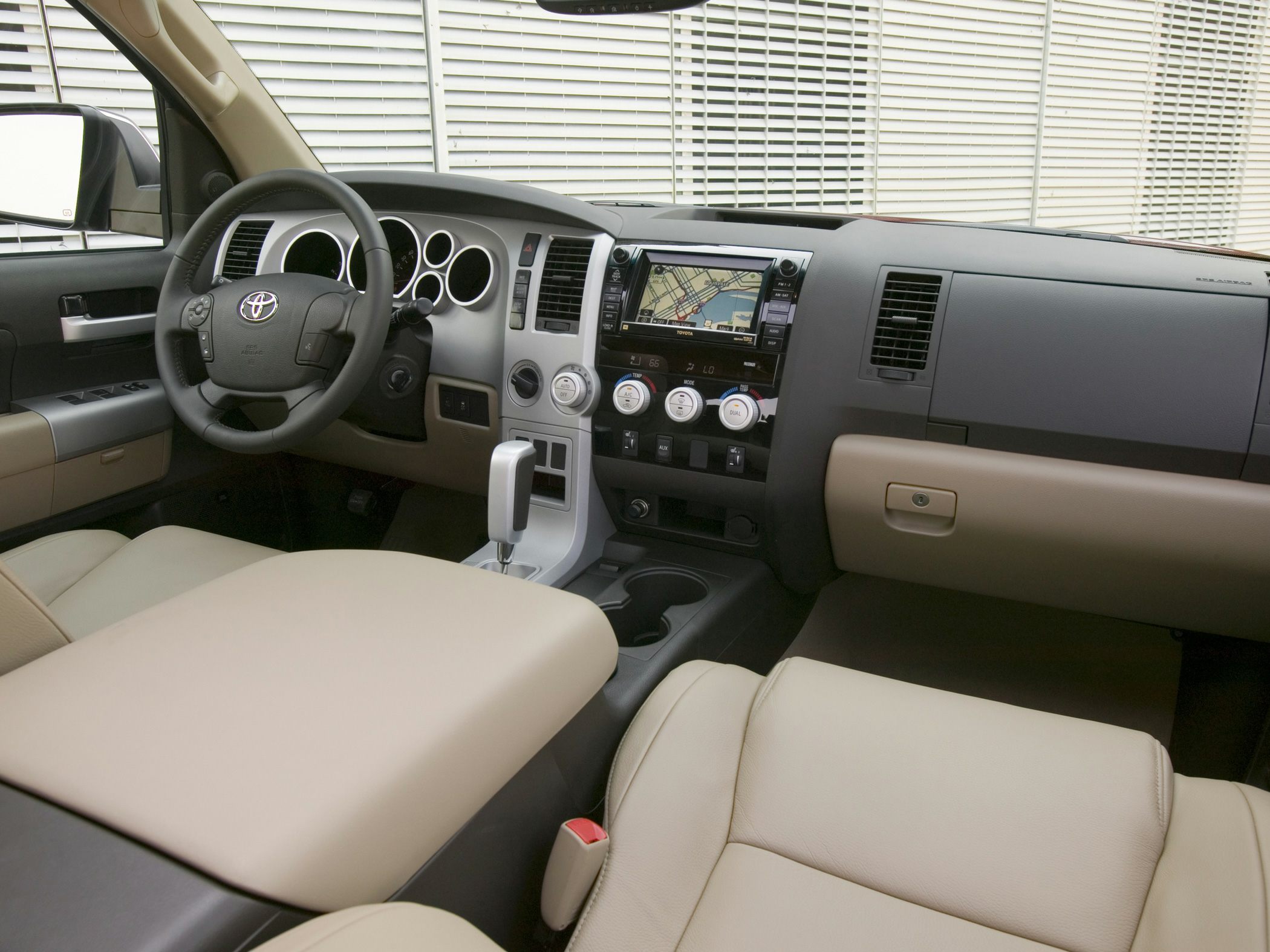 Beige interior dashboard with steering wheel and navigation system