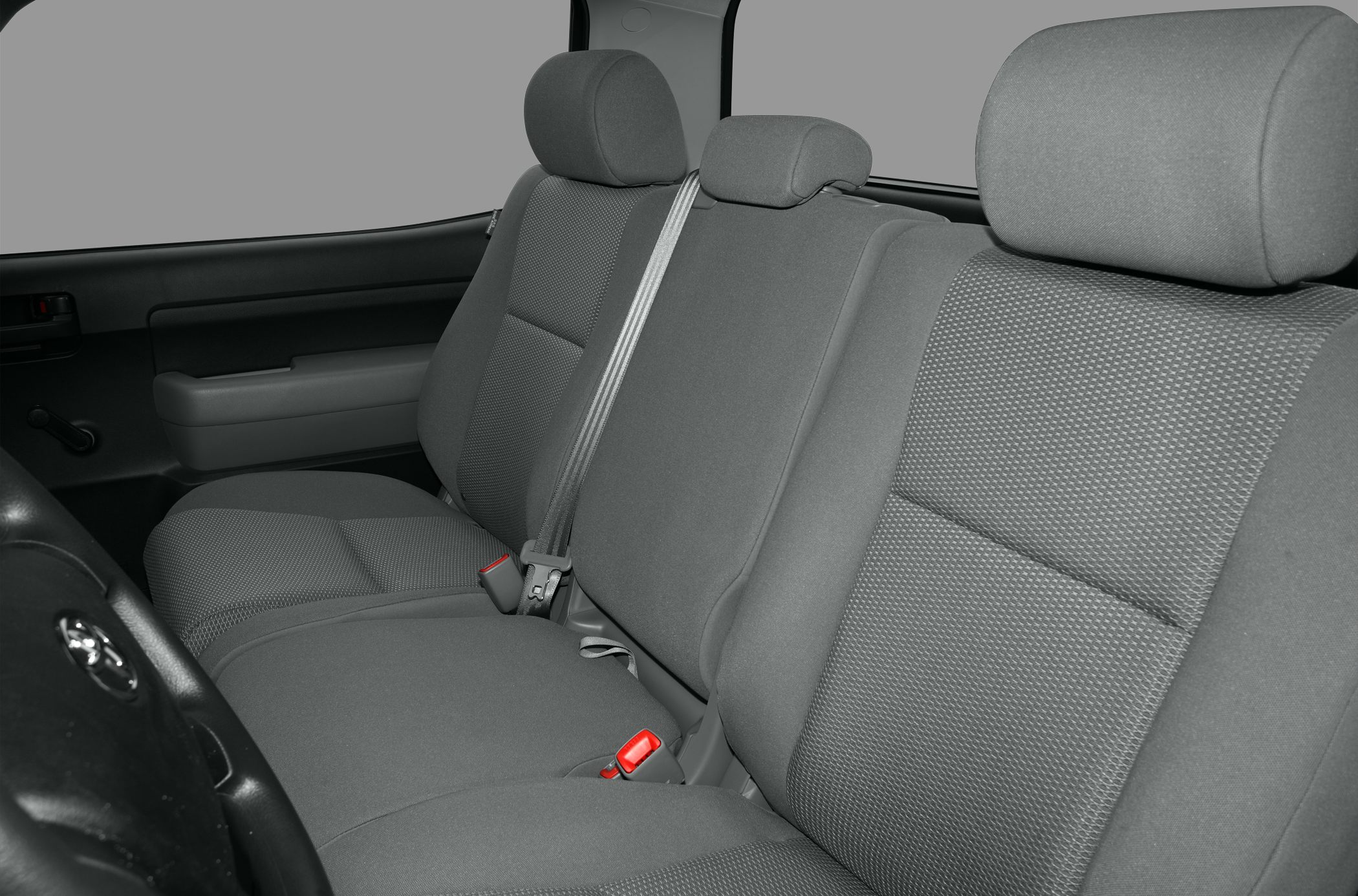 Grey fabric bench seat with headrests and seatbelt in truck interior
