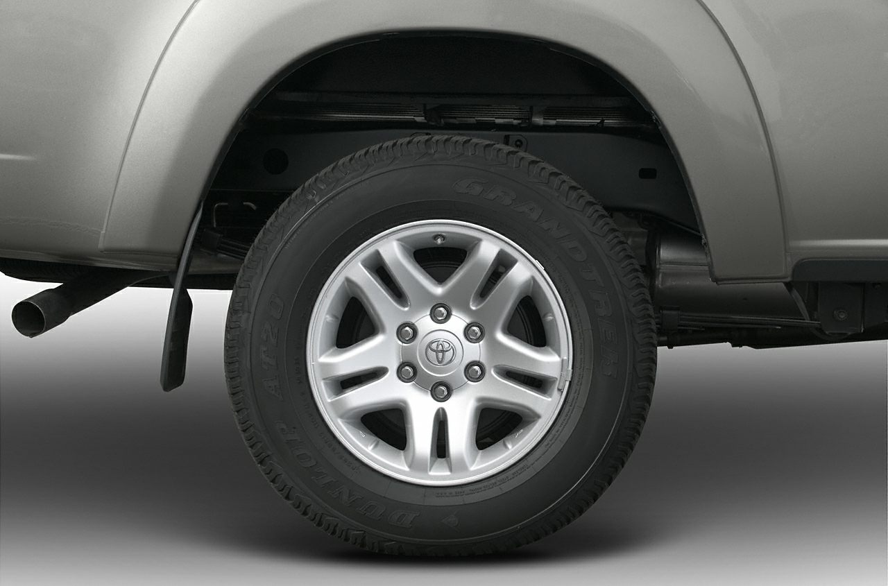 Close-up of tire and alloy wheel with visible tread and truck suspension.