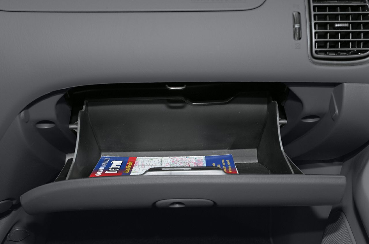 Open glove compartment with map inside in vehicle interior