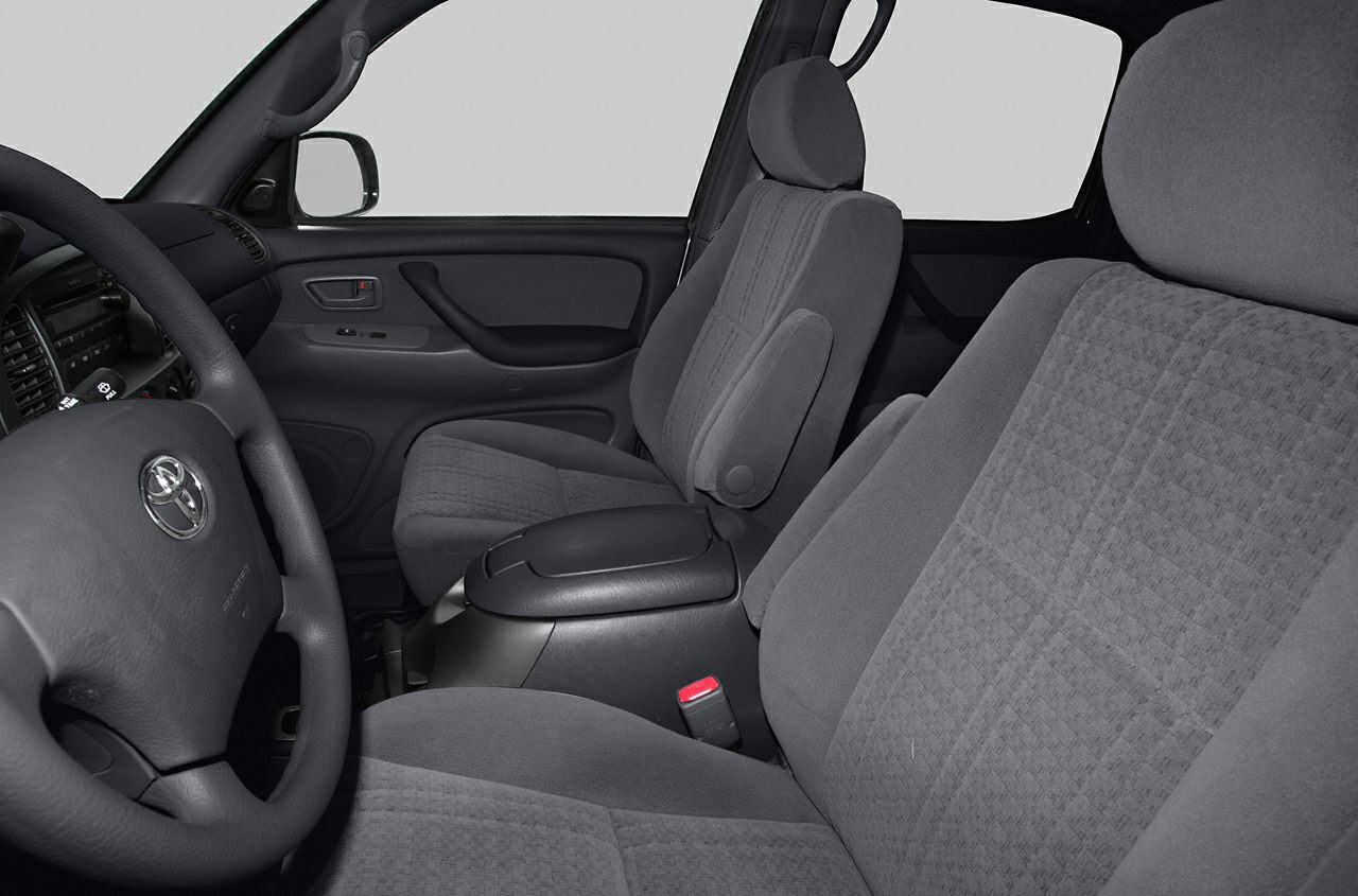 Fabric seats, central armrest, steering wheel, and door panel inside truck cabin