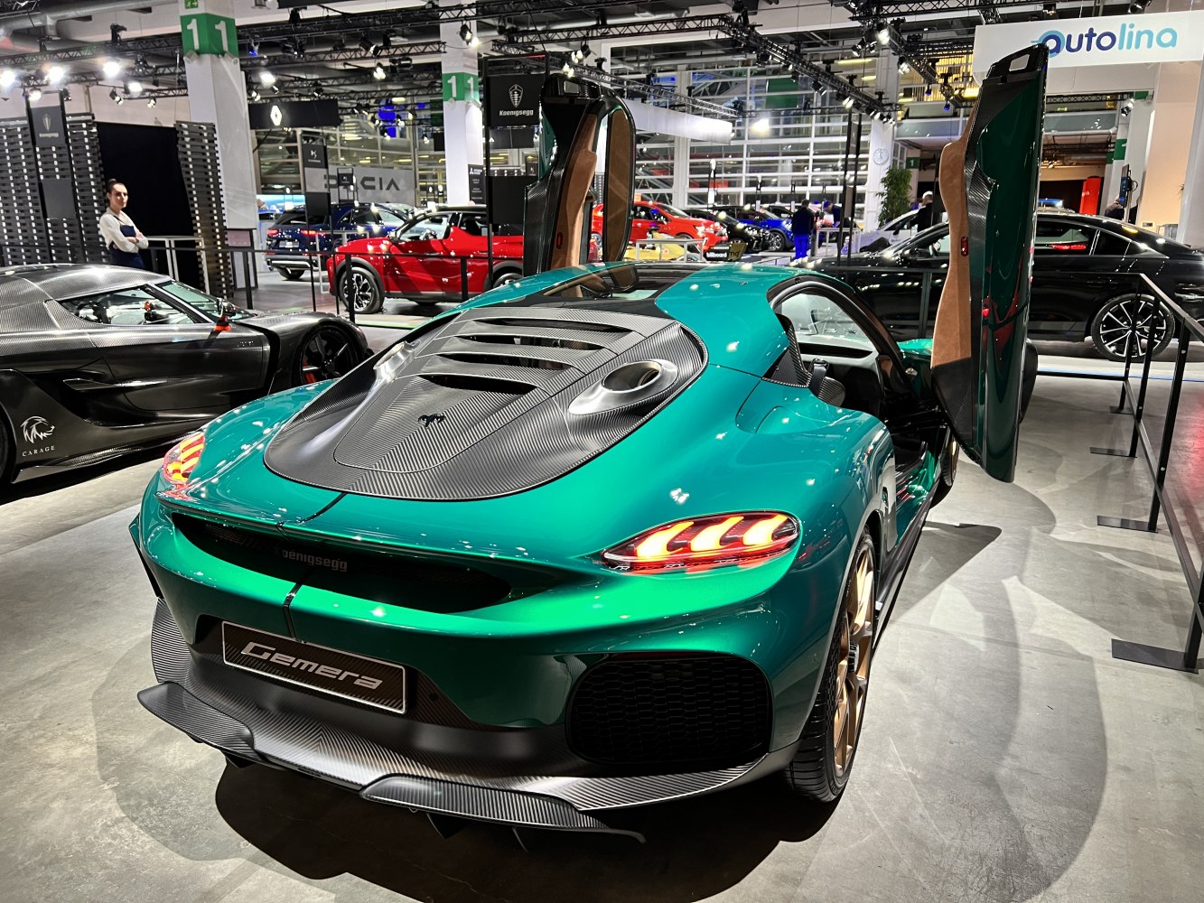 Rear view of a luxury sports car with butterfly doors open and carbon fiber detailing