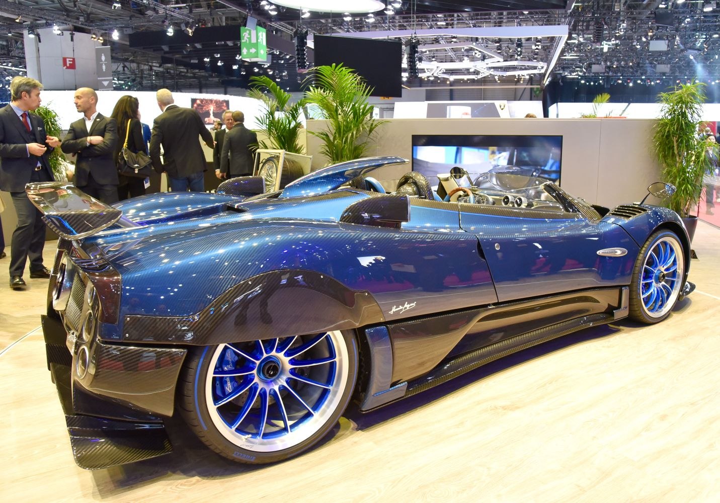 Rear and side view of open-top car with carbon fiber body and blue wheels