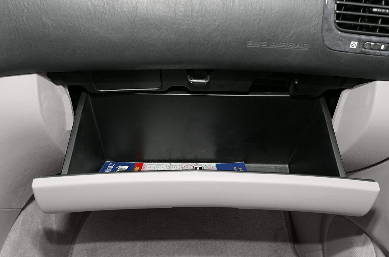 Open glove compartment with visible storage space and a folded map