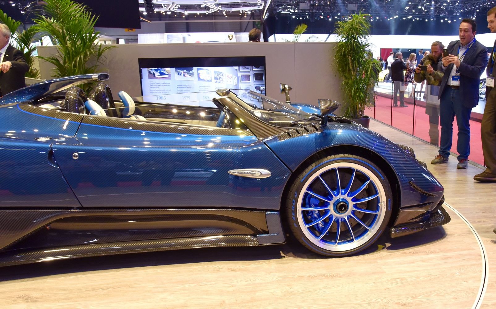 Open cockpit hypercar with blue carbon fiber body and blue-rimmed wheels