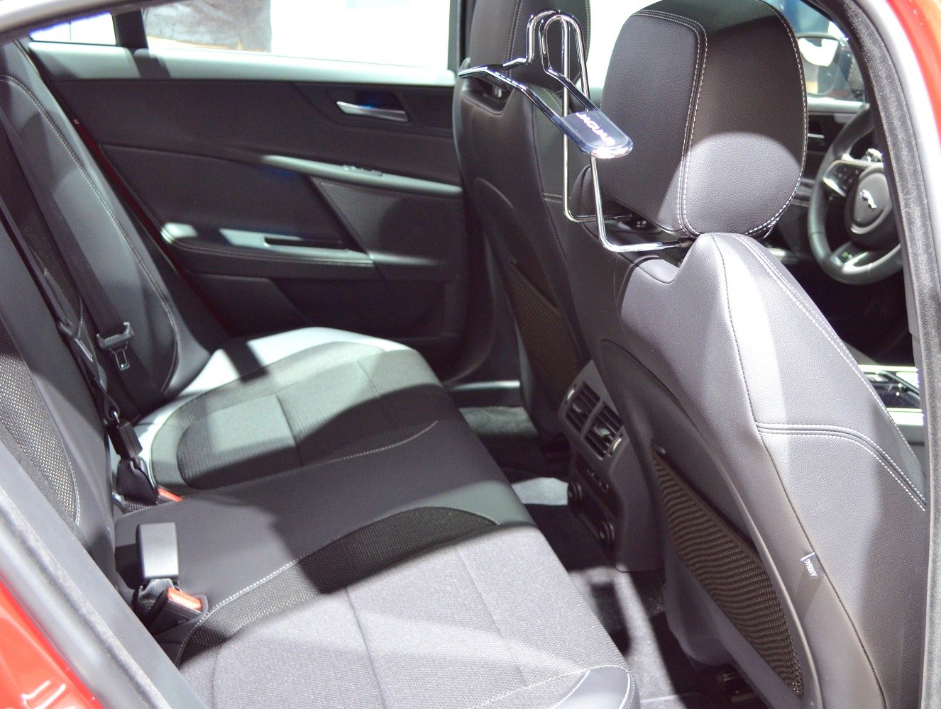 Rear interior with leather seats, air vents, and seatback hanger