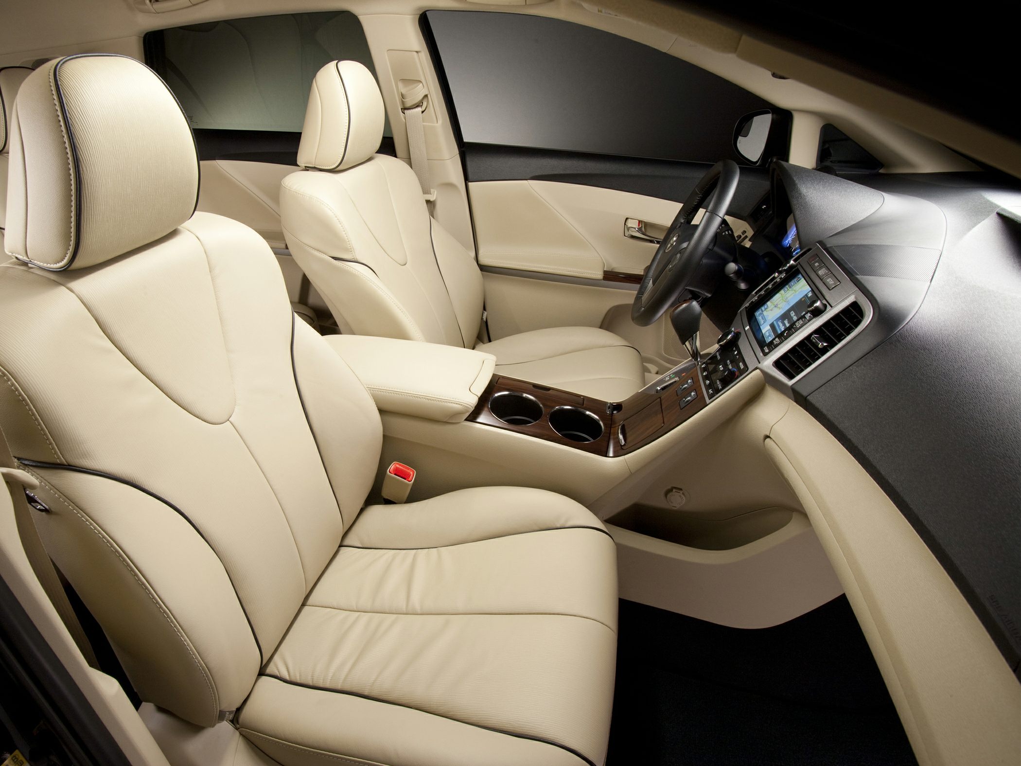 Beige leather front seats with wood trim center console and navigation screen