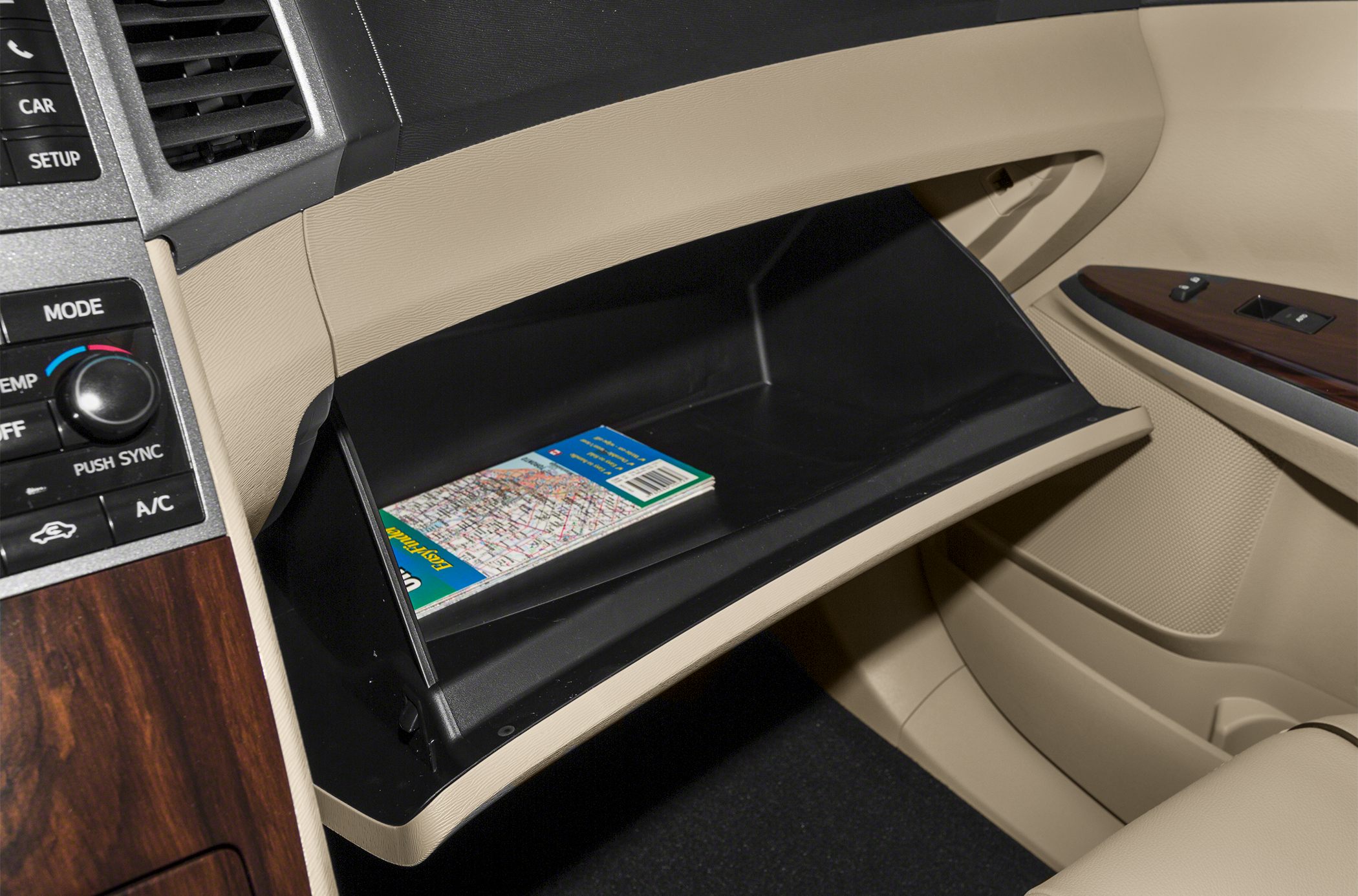 Beige glove compartment with map inside, part of car interior storage