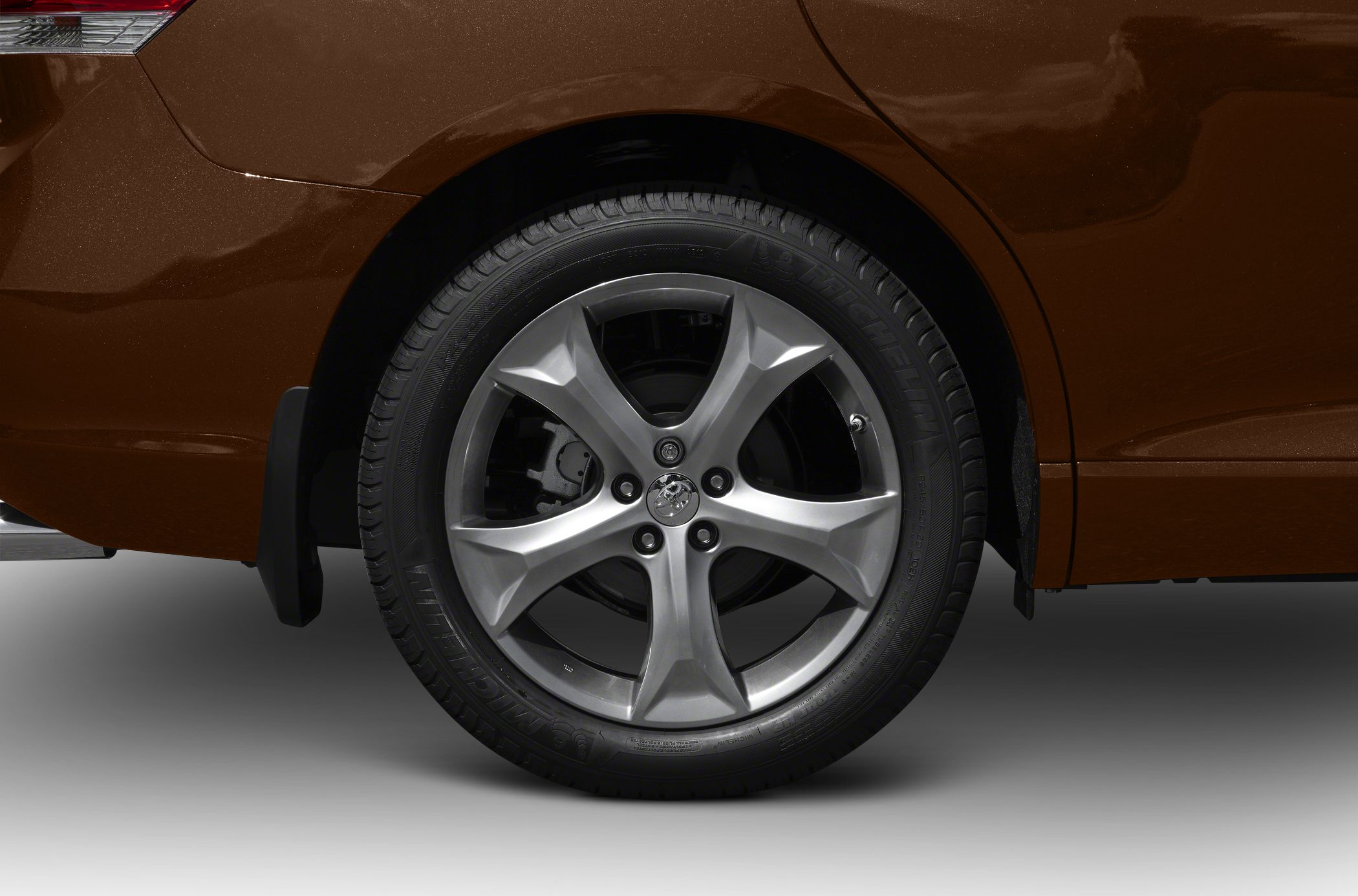 Close-up of alloy wheel with Michelin tire on dark brown vehicle