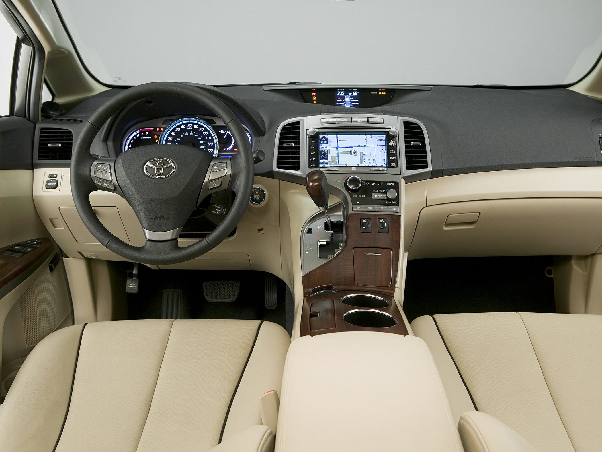 Interior dashboard with steering wheel, GPS touchscreen, and wood trimmed center console