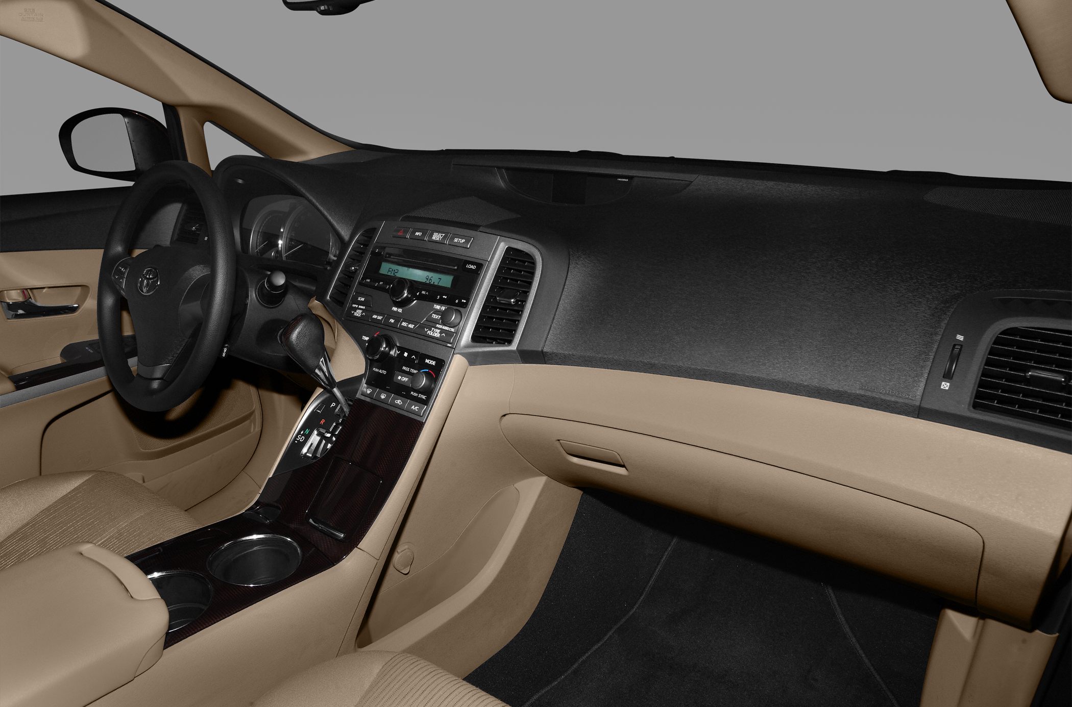 Dashboard and center console with gear shift and cup holders in beige interior