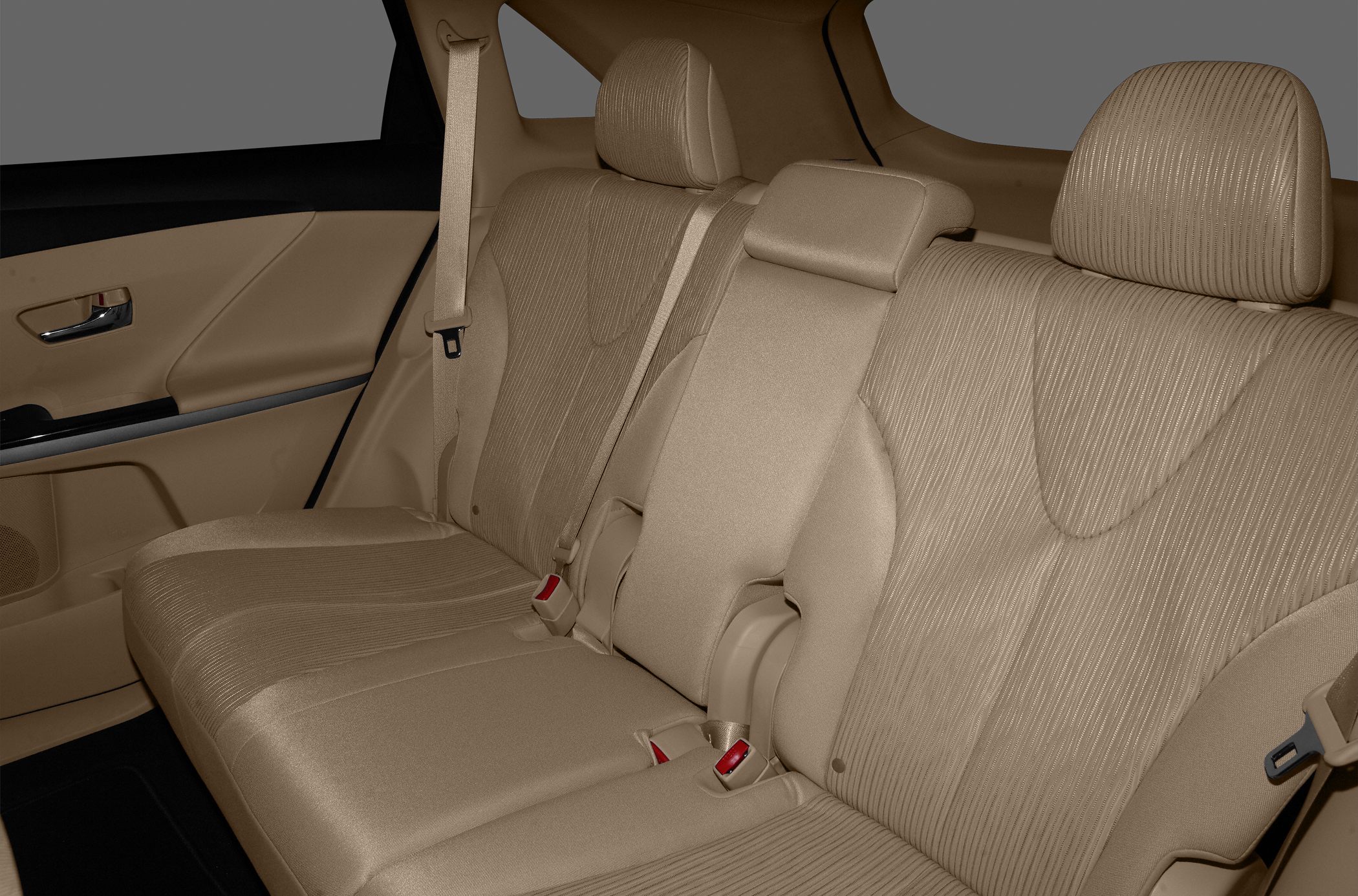 Rear seat interior with beige upholstery, headrests, and seat belts.
