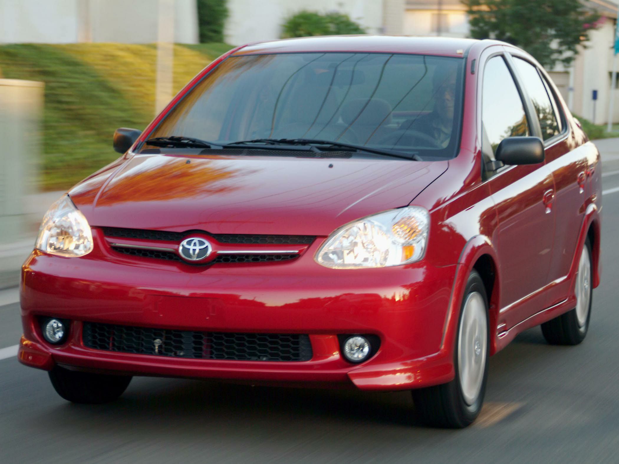Red sedan front with headlights and motion blur