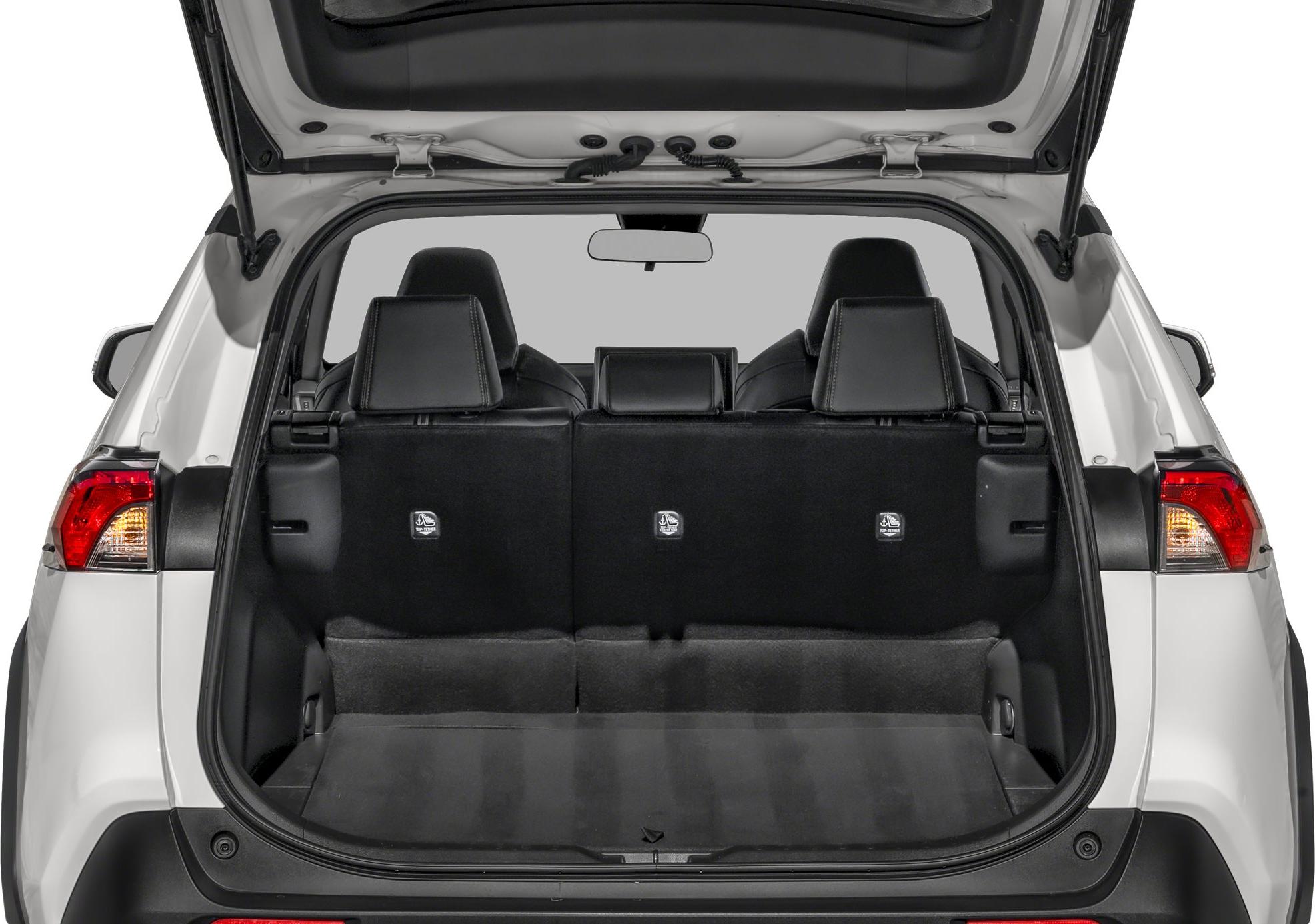 Open rear cargo space with folded rear seats in a white SUV