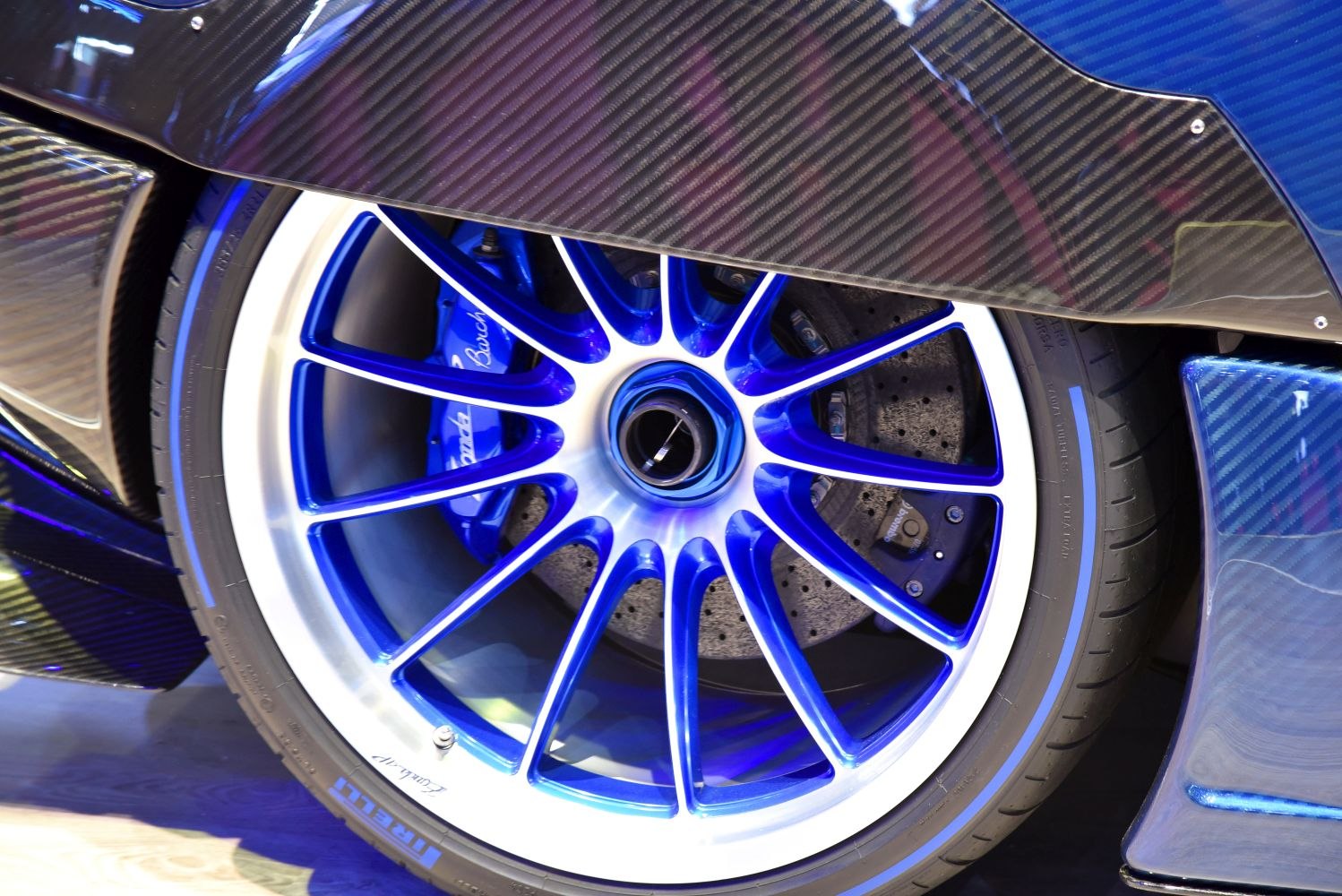 Blue alloy wheel with carbon fiber bodywork and Brembo brake caliper