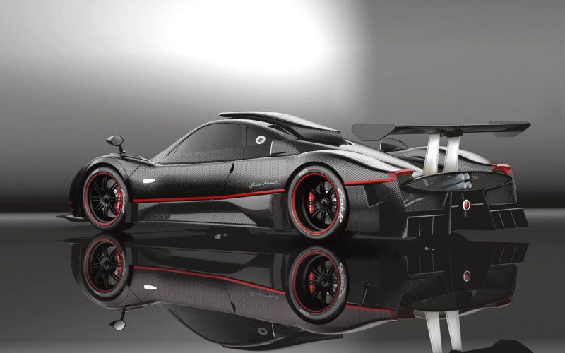 Sleek carbon fiber racing supercar with large rear wing and distinctive aerodynamic design