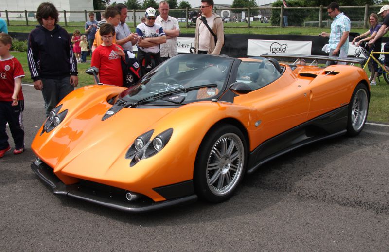 Sleek orange supercar with aerodynamic body and distinct quad headlights.