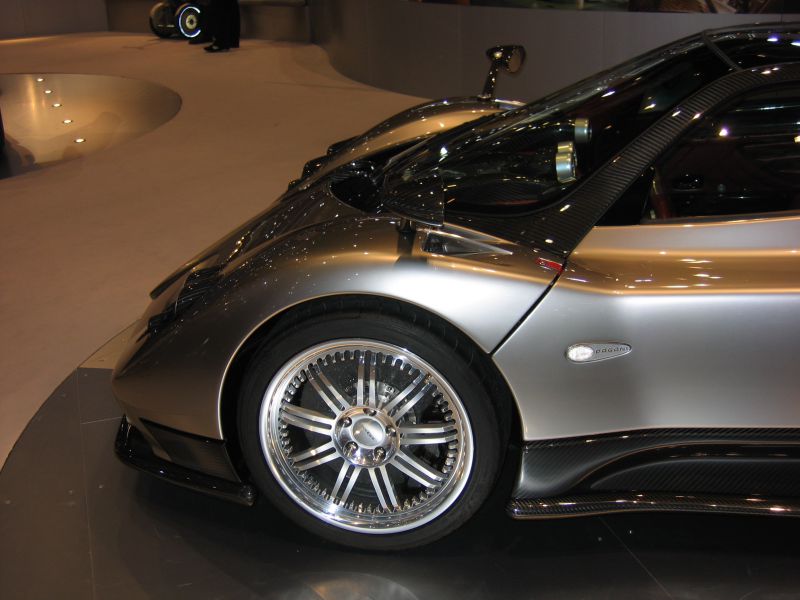 Rear wheel, carbon fiber side panel, and metallic body detail of a high-performance sports car