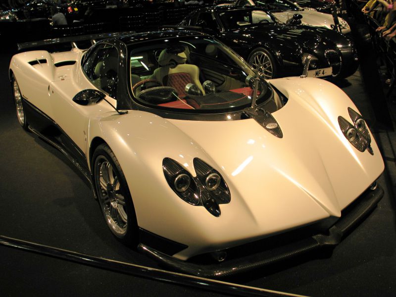 Close-up of white hypercar front with unique twin headlights and visible interior
