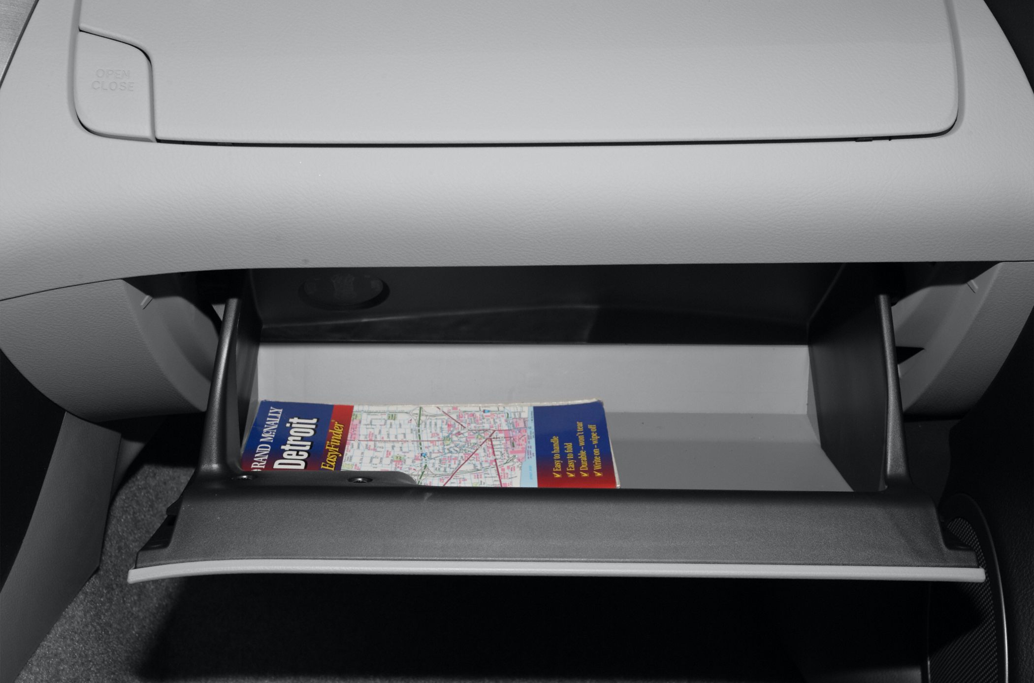 Open glovebox compartment with map inside in car interior