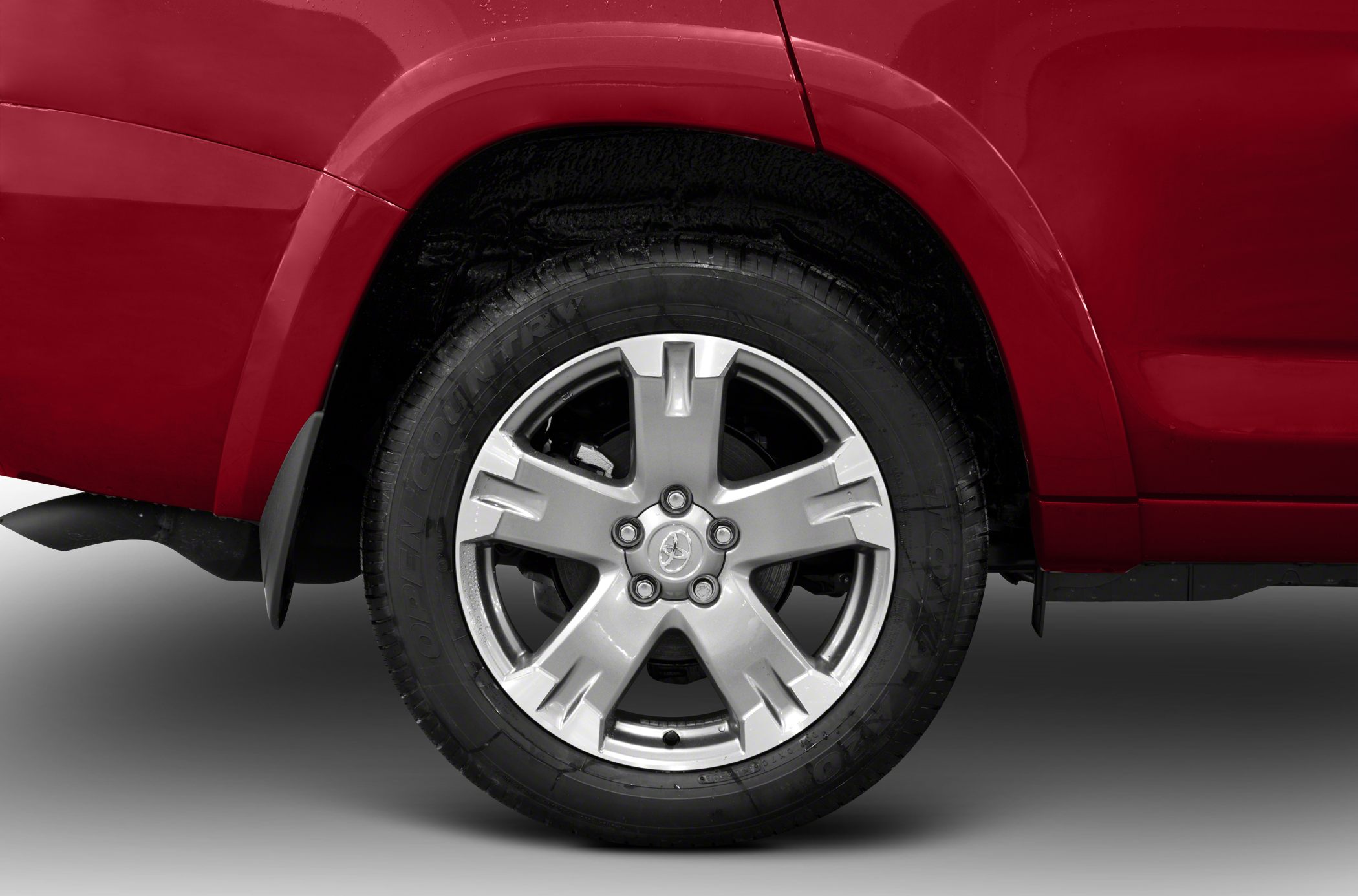 Detailed alloy wheel and tire close-up on red vehicle side
