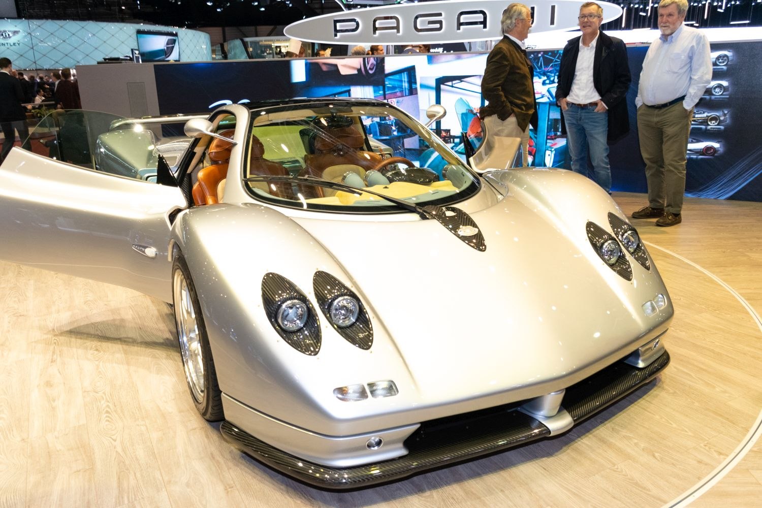 Close-up front with unique headlights, open door, and brown leather interior