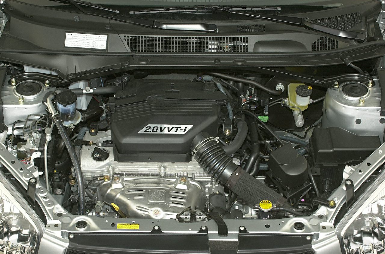 Close-up of a 2.0 VVT-i engine inside an engine bay with hoses and components