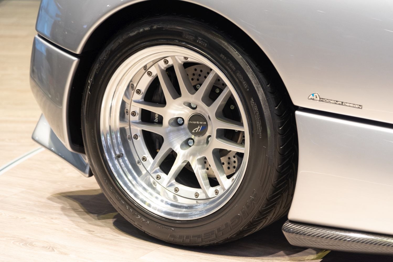 Close-up of alloy wheel and drilled brake disc with carbon fiber side skirt