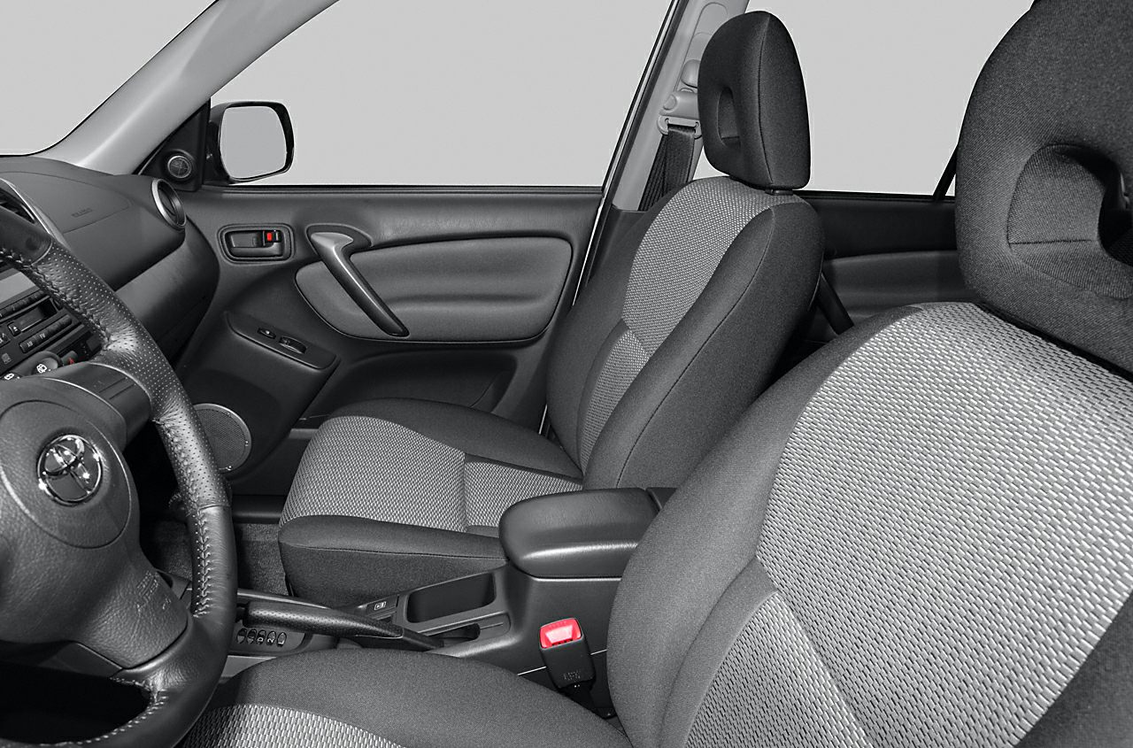 Front seats and dashboard interior with fabric upholstery and steering wheel.