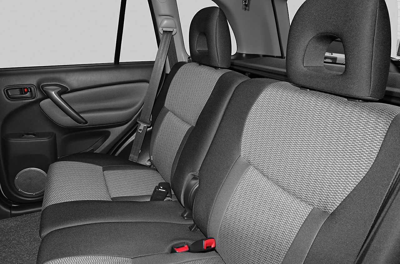 Rear seat with fabric upholstery, seatbelts, and door panel.
