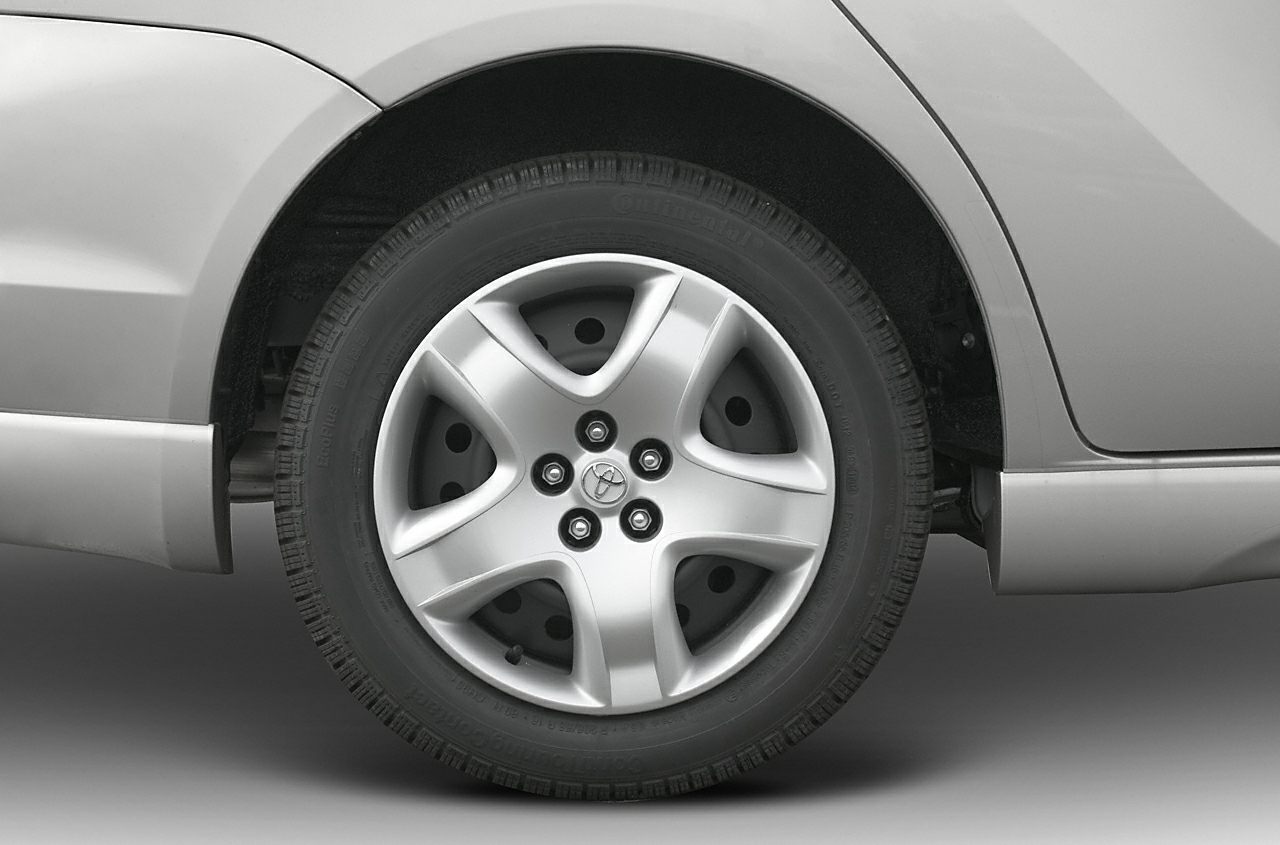 Close-up of a 5-spoke alloy wheel and tire on vehicle rear side.