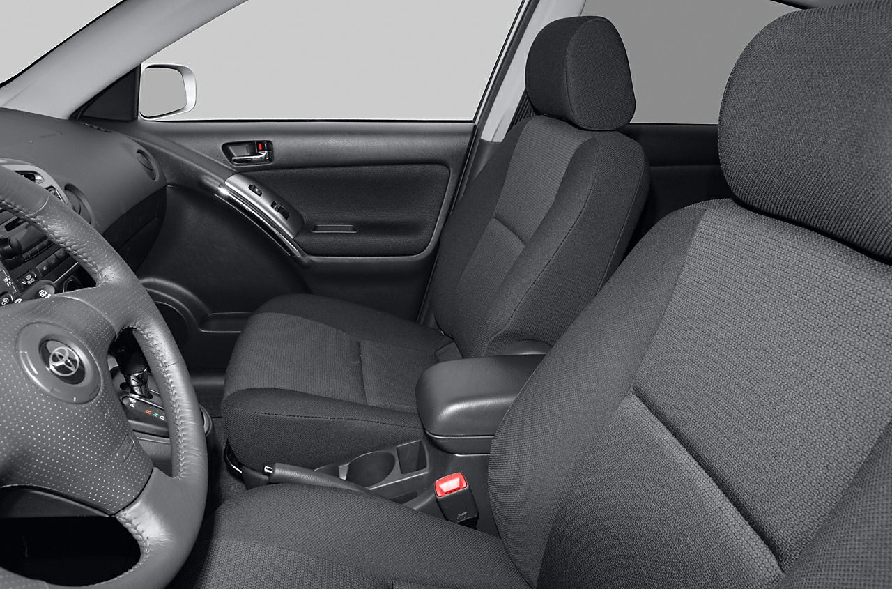 Front seats and dashboard interior with fabric upholstery and steering wheel.