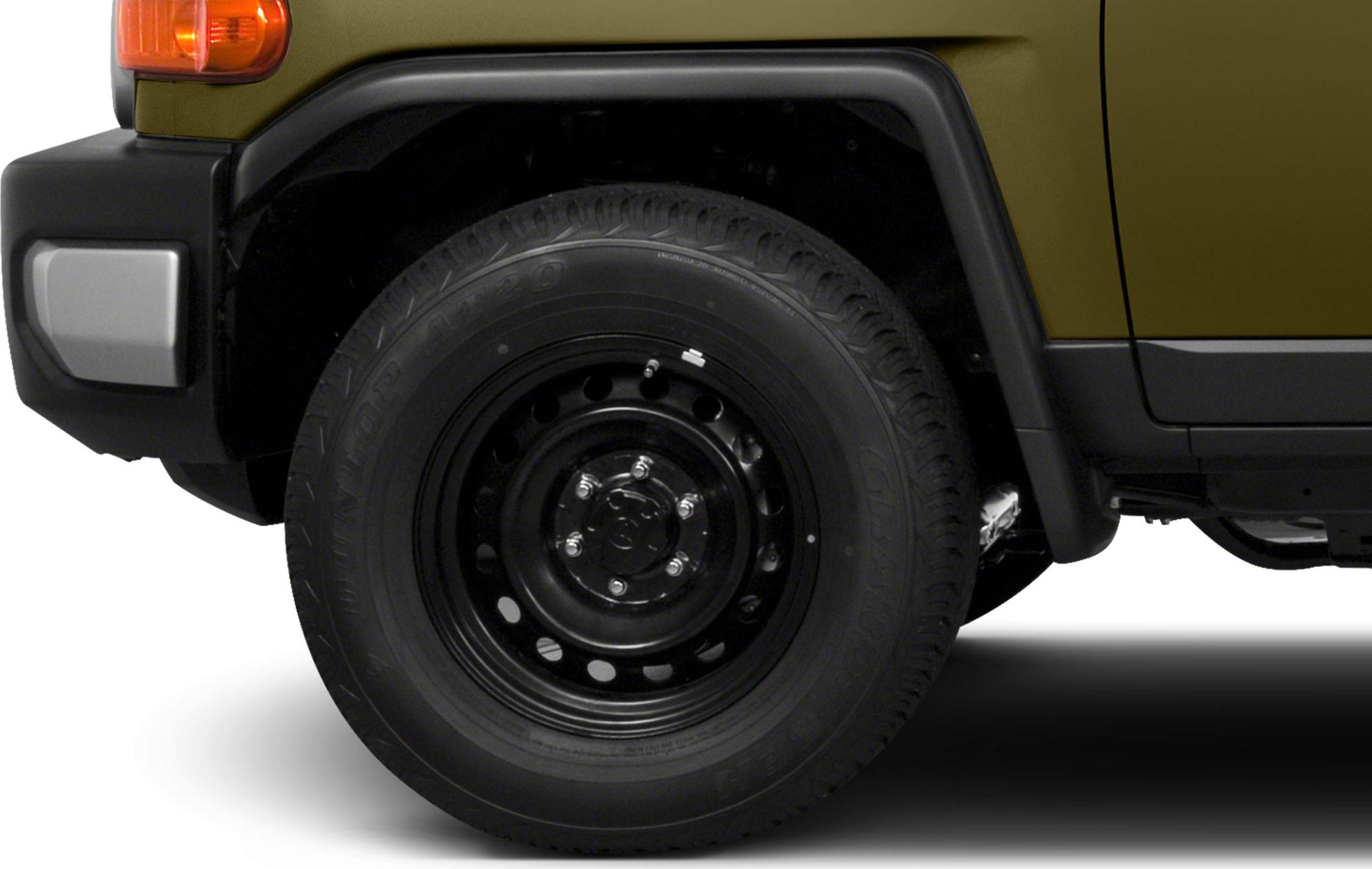 Close-up of front wheel and fender with rugged steel rim and tire tread.