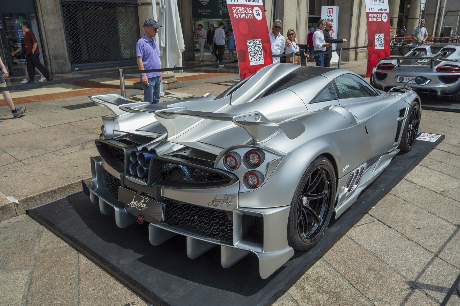 Silver sports car rear with quad exhausts, diffusers, and large wing