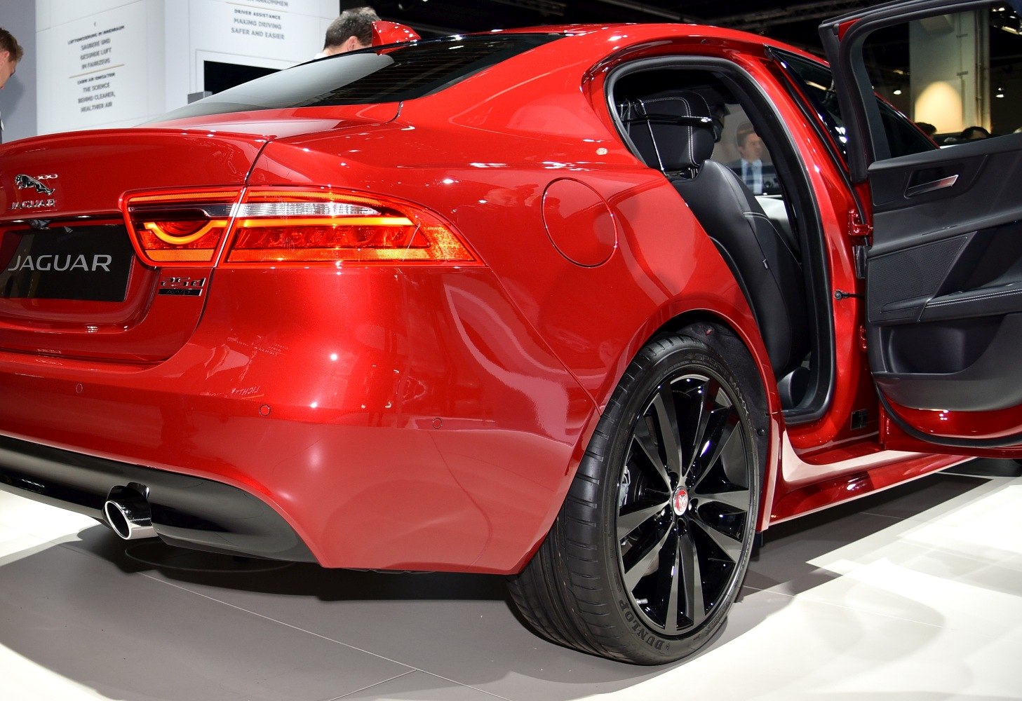 Rear view with tail lights, open door, and black alloy wheels