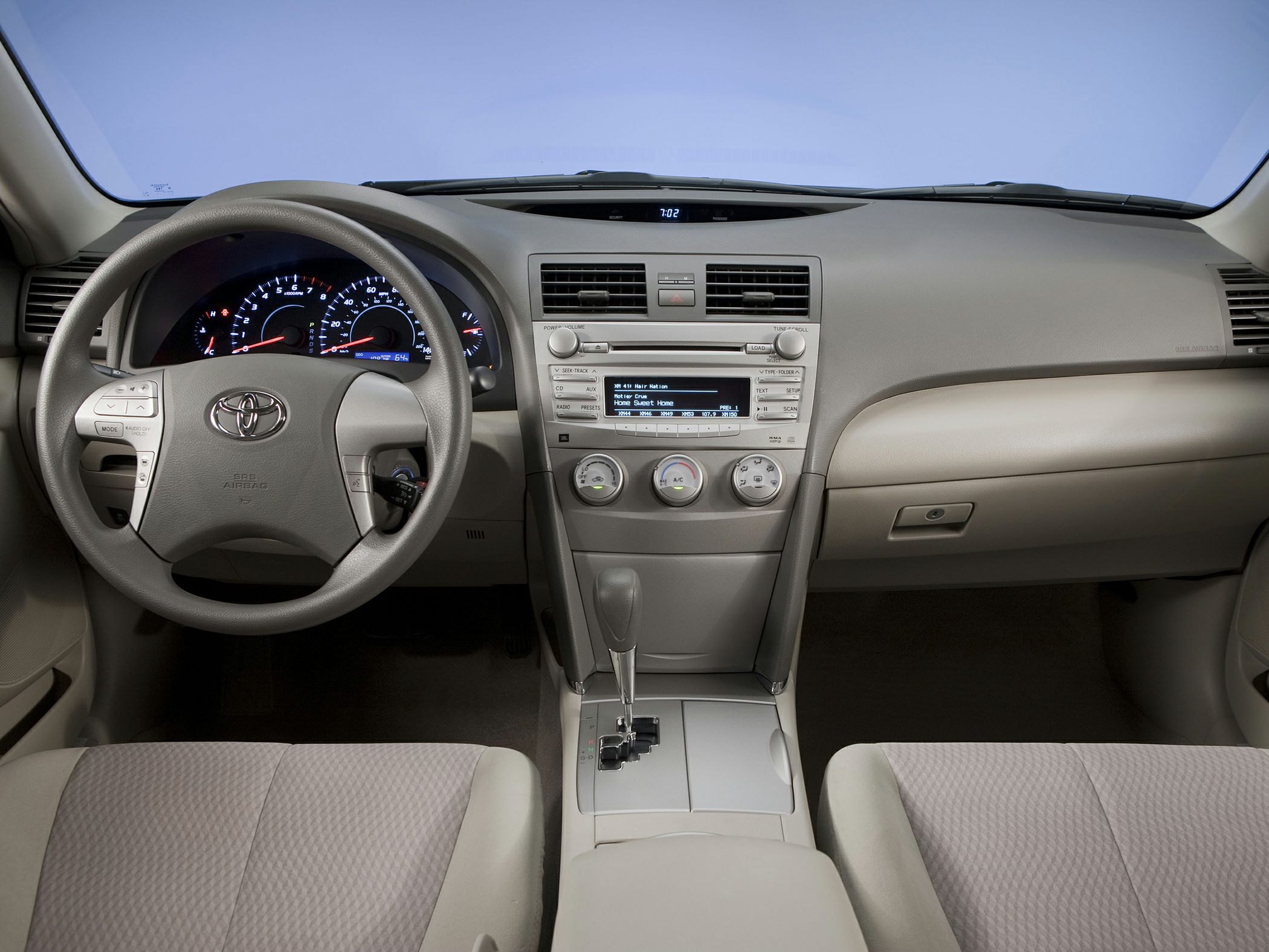 Steering wheel, dashboard gauges, center console with audio and climate controls