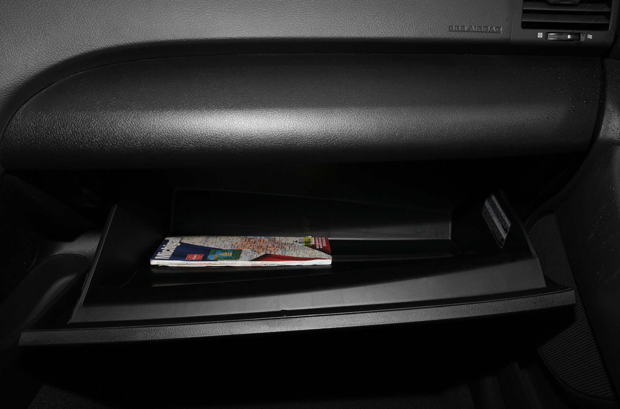 Open glovebox compartment with map inside