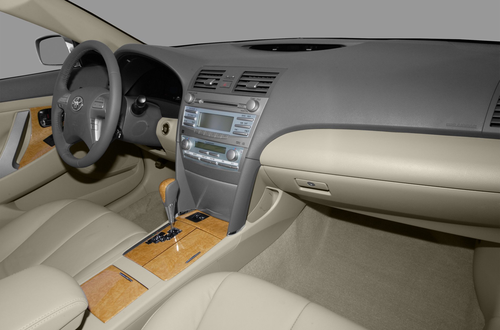 Dashboard and center console with wood-grain trim and beige leather seats