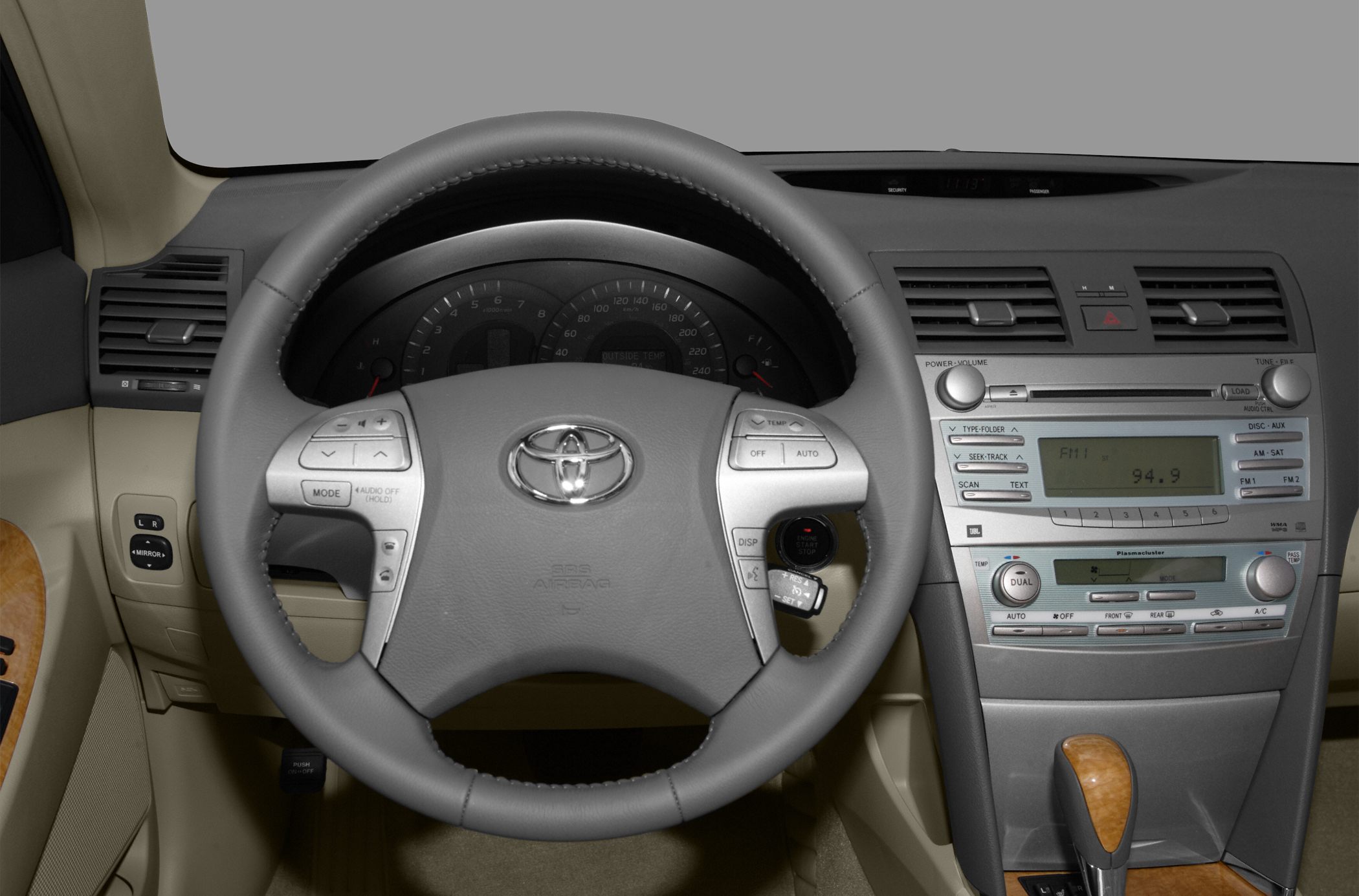 Steering wheel and dashboard with center console featuring audio and climate controls.