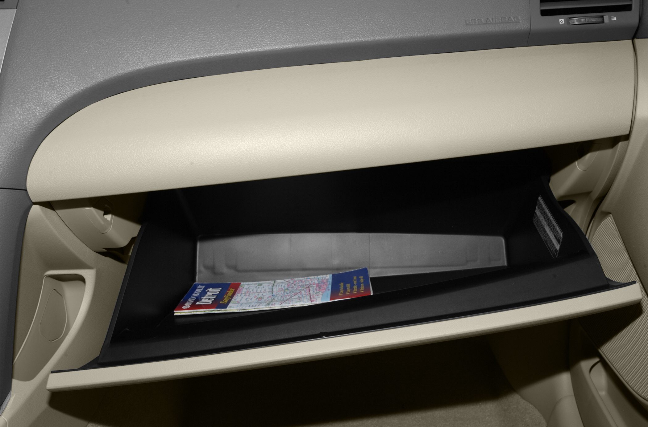 Beige open glove compartment with map inside