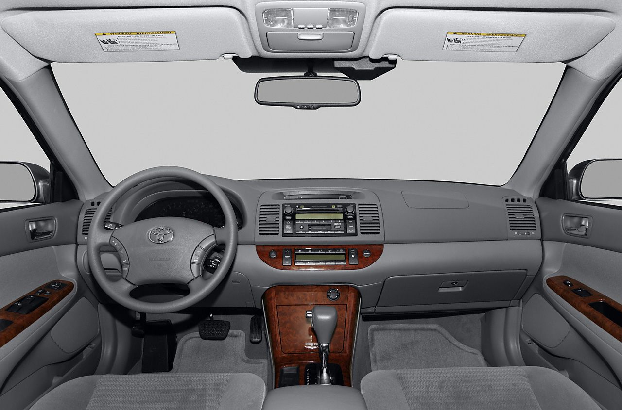 Dashboard and center console featuring wood trim, steering wheel controls.