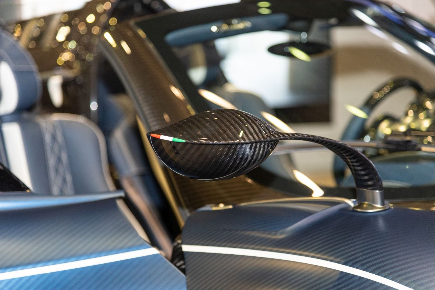 Carbon fiber side mirror with Italian flag detail on luxury sports car interior