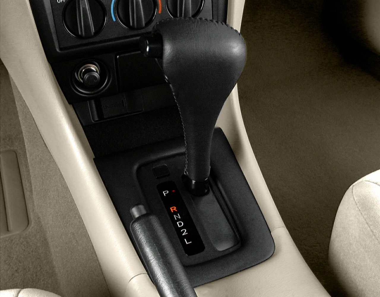 Automatic gear shift lever and handbrake in beige car interior