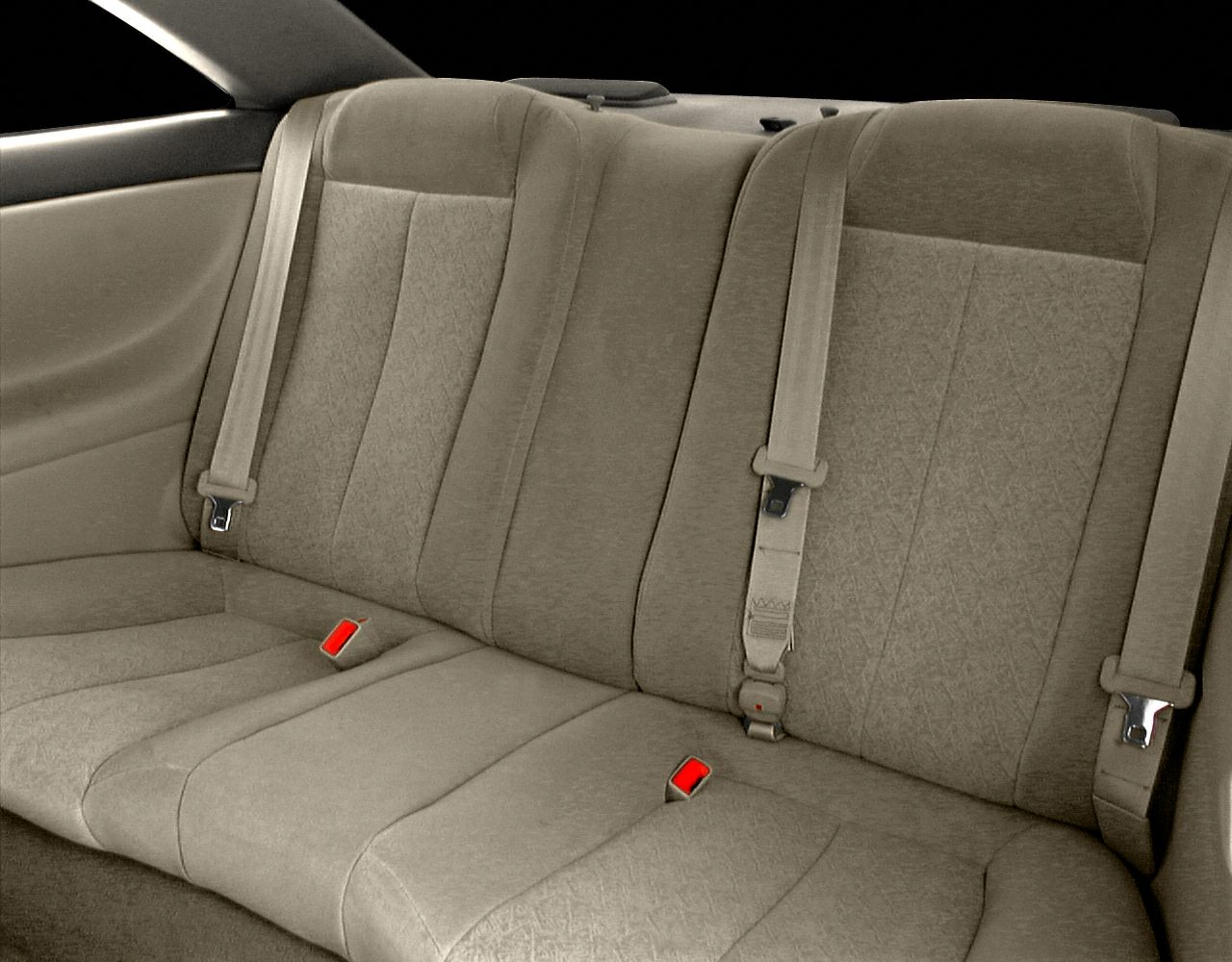 Rear seat upholstery and seat belts in a beige fabric interior.