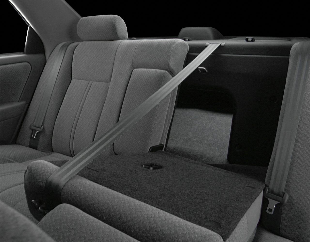 Rear seat interior with split-folding backrest and integrated seatbelt.