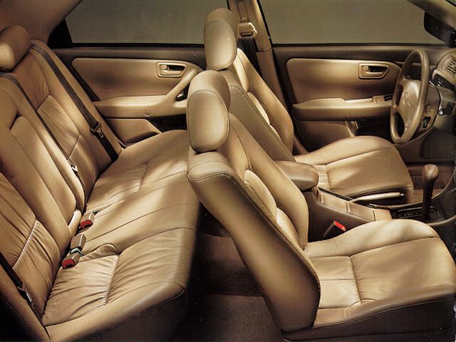 Spacious beige leather interior with front and rear seats.