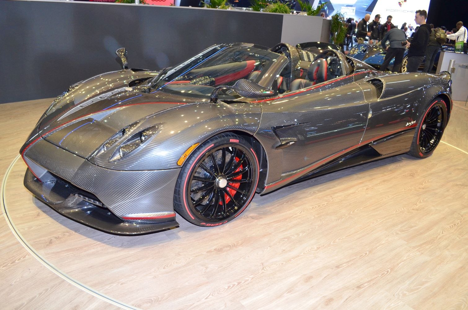 Carbon fiber body with open roof and black alloy wheels featuring red accents.